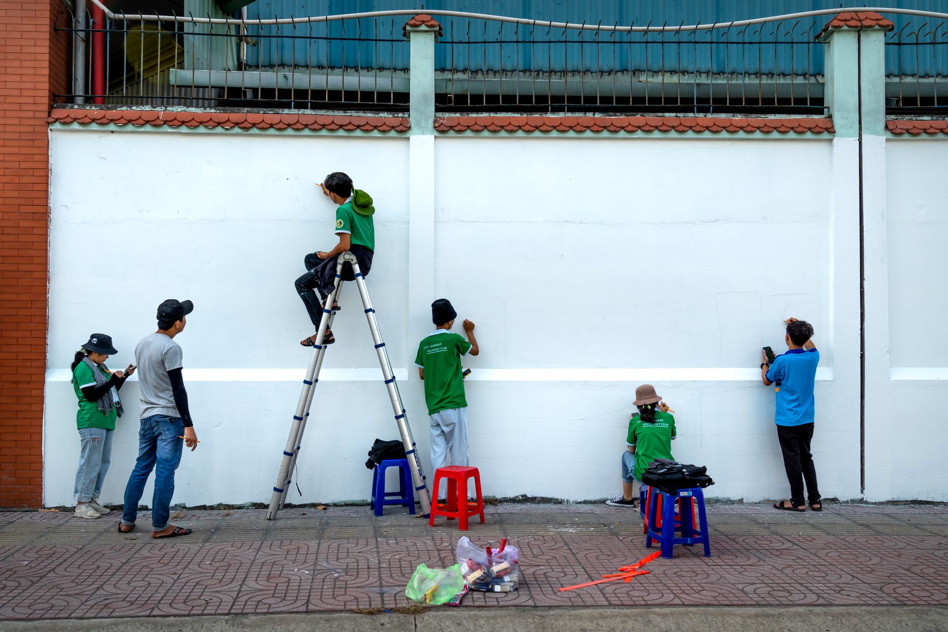Young volunteers painting a mural